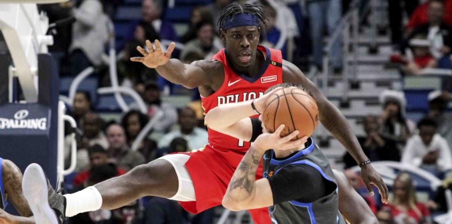 El jugador de los Pelicans, Jrue Holiday defiende al novato de los Mavericks, Luka Doncic. (AP) (horizontal-x3)