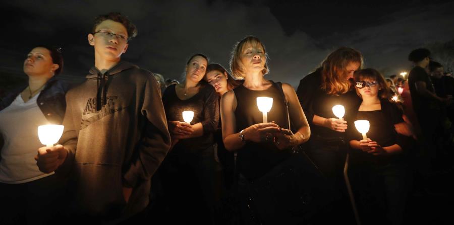 Gente participa en una vigilia en memoria de 17 estudiantes y maestros abatidos en la escuela secundaria Marjory Stoneman Douglas en Parkland, Florida, 19 de febrero de 2018 (horizontal-x3)