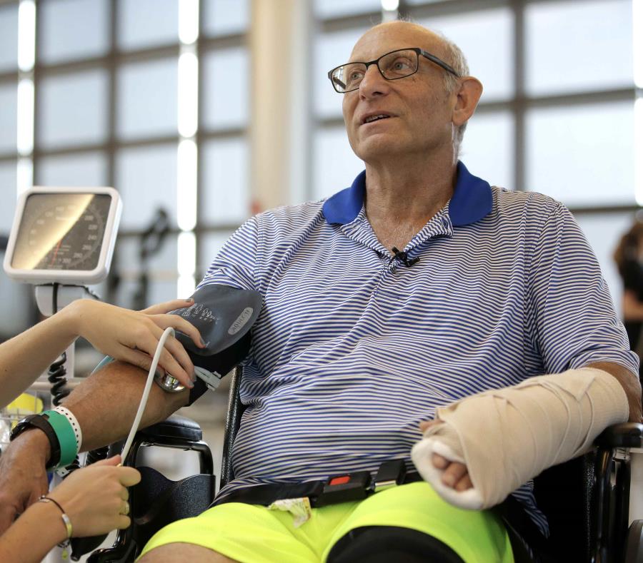 A William Lytton, de Scarsdale, Nueva York, derecha, le revisa la terapeuta física Caitlin Geary los signos vitales en el hospital de rehabilitación Spaulding en Boston el martes 28 de agosto de 2018 (semisquare-x3)