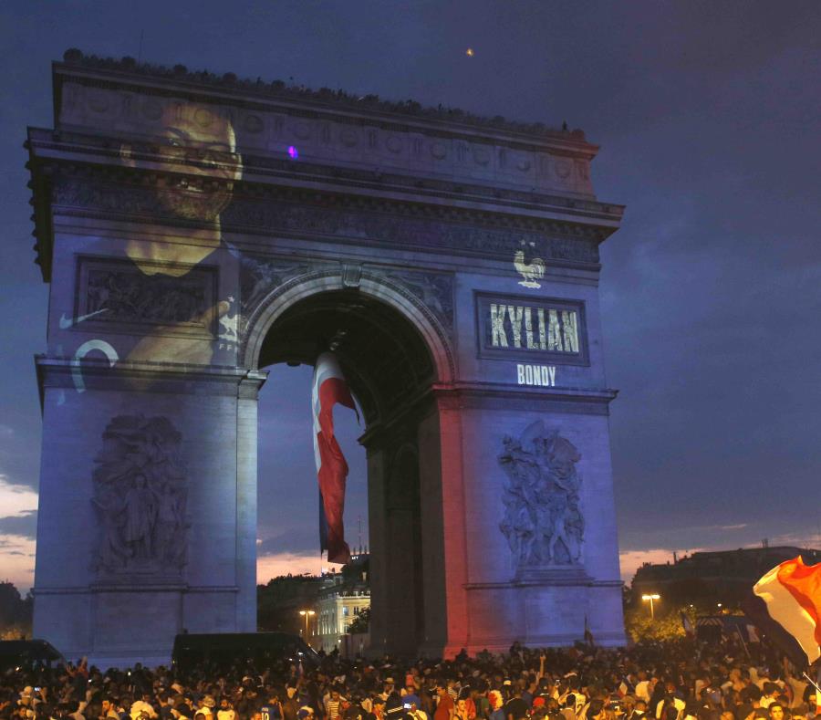 El nombre del jugador de la selección de Francia Kylian Mbappe, proyectado sobre el Arco del Triunfo mientras aficionados al fútbol invaden la avenida de los Campos Elíseos tras la victoria de su equipo sobre Croacia en la final del Mundial de Rusia, el 1 (semisquare-x3)
