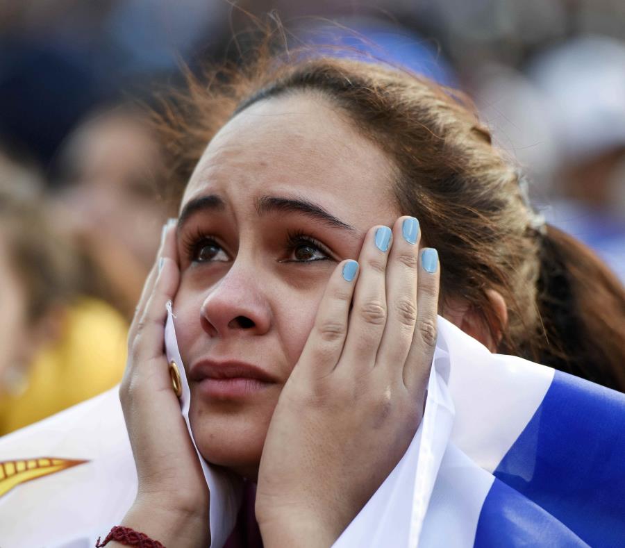 Una seguidora de la selección de Uruguay observa la transmisión del partido del Mundial entre Francia y Uruguay en el centro de Montevideo. (AP) (semisquare-x3)