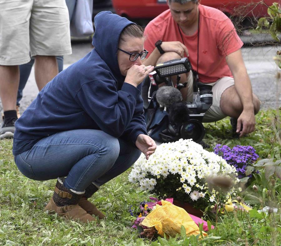 Una mujer aparece enfrente de un altar improvisado en el lugar donde el día previo chocó una limusina dejando 20 muertos, en Schoharie, Nueva York. (AP) (semisquare-x3)