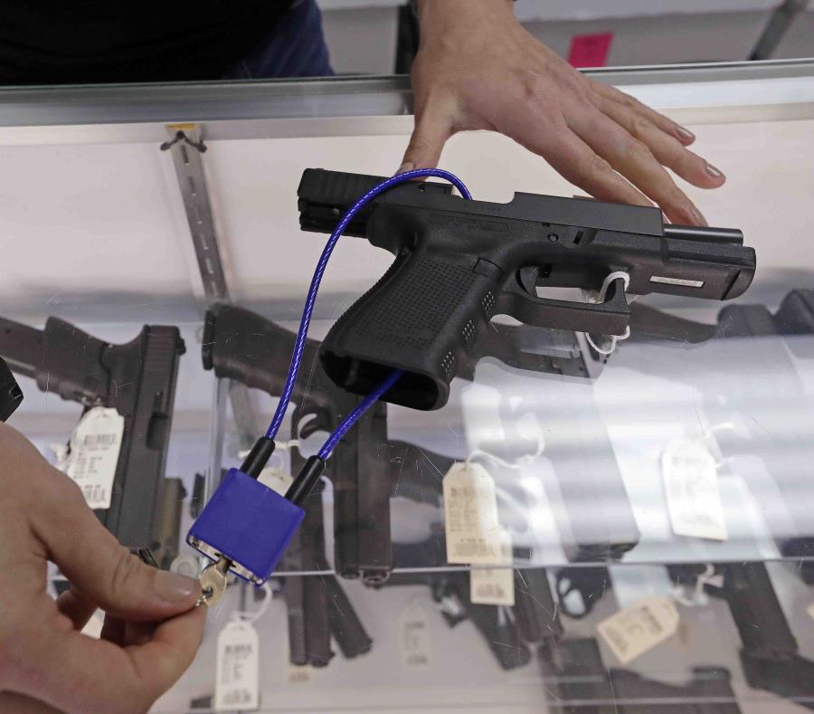 Un empleado de una armería muestra varias armas. (AP) (semisquare-x3)