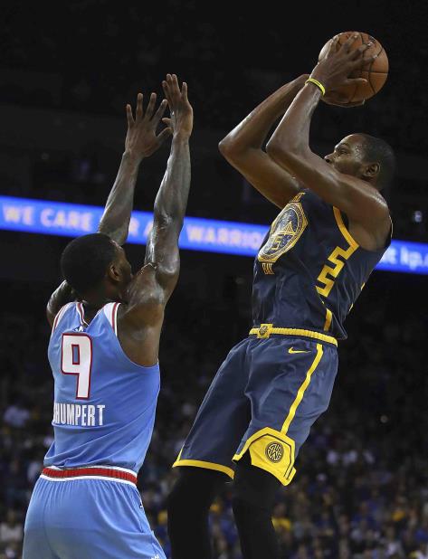 Kevin Durant, de los Warriors de Golden State, dispara por encima de Iman Shumpert, de los Kings de Sacramento, en la segunda mitad del encuentro del sábado 24 de noviembre de 2018 en Oakland, California. (AP Foto/Ben Margot) (vertical-x1)