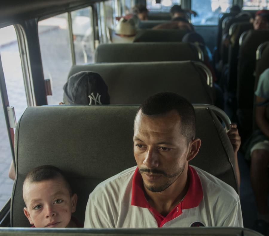 Migrantes hondureños aguardan en un autobús de la policía luego de que aceptaran voluntariamente regresar a su país, en Tecún Umán, Guatemala. (AP / Oliver de Ros) (semisquare-x3)