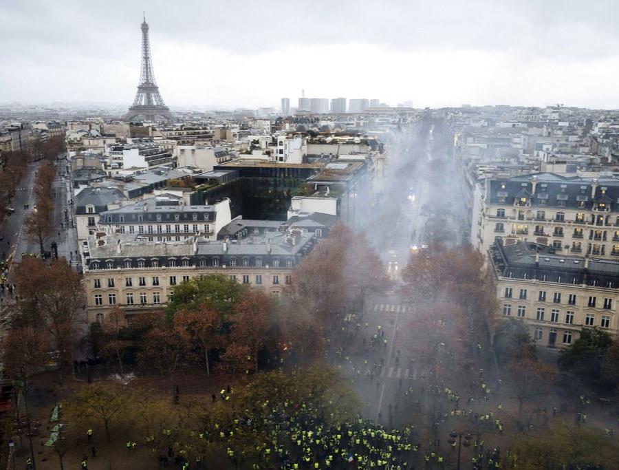 Manifestantes vestidos con chalecos amarillos se enfrentan a los cañones de agua de la policía durante una protesta cerca de la avenida de los Campos Elíseos, en París, el 1 de diciembre de 2018. (AP Foto/Kamil Zihnioglu) (semisquare-x3)