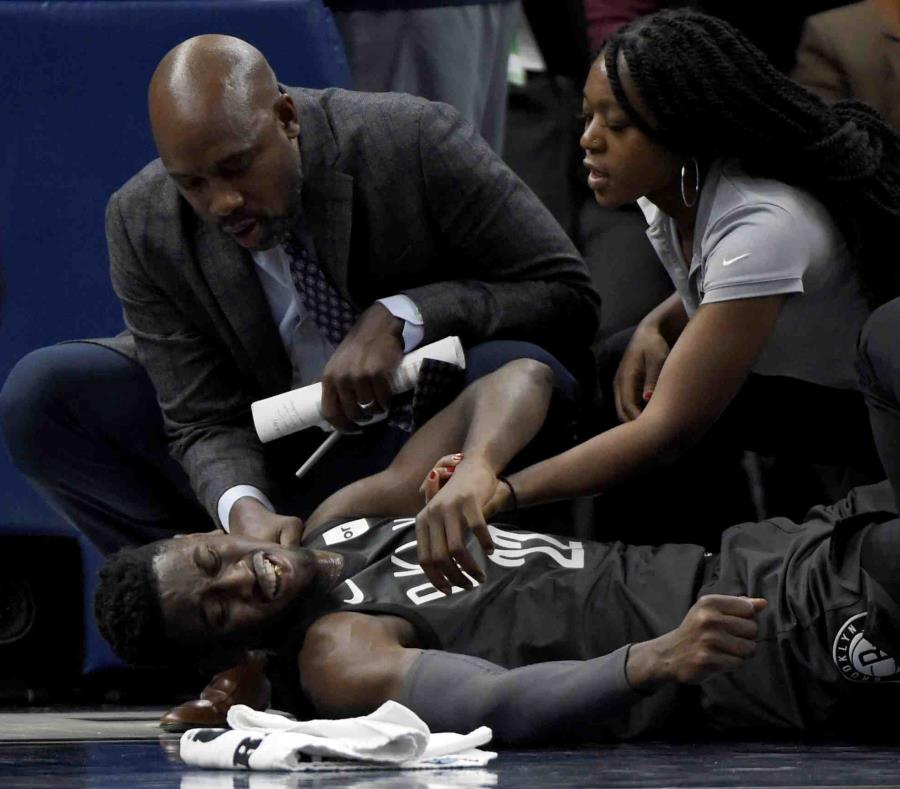 El escolta de los Nets de Brooklyn, Caris LeVert (22), es atendido en la duela luego de sufrir una lesión en el tobillo. (semisquare-x3)