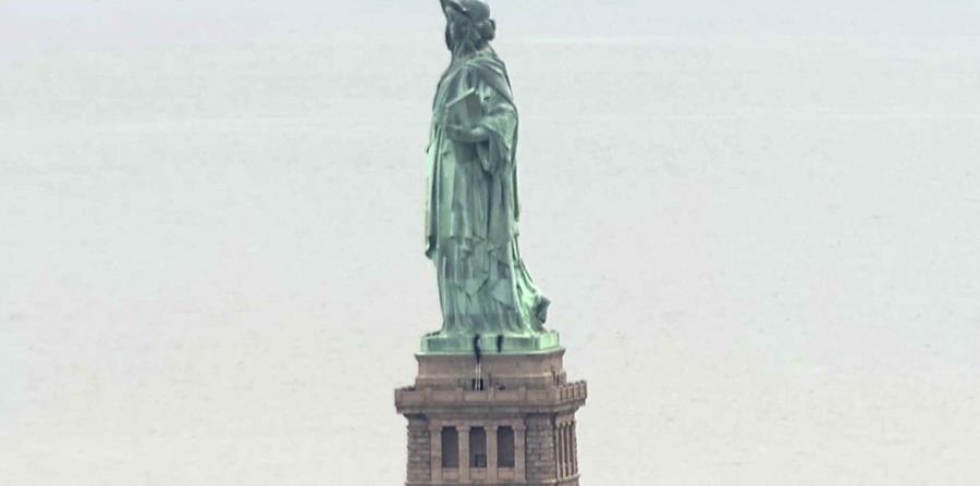 Personas escalando el pedestal de la Estatua de la Libertad. (AP) (horizontal-x3)