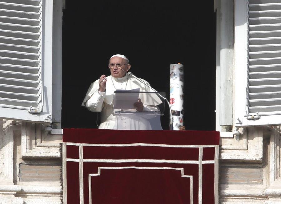 Una vela decorada con caras de niños sirios afectados por la guerra está colocada junto al papa Francisco durante la oración del Angelus en la ventana de su estudio sobre la Plaza de San Pedro, Vaticano (semisquare-x3)