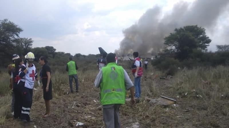 Rescatistas intentan llegar hasta el avión incendiado. (AP) (horizontal-x3)