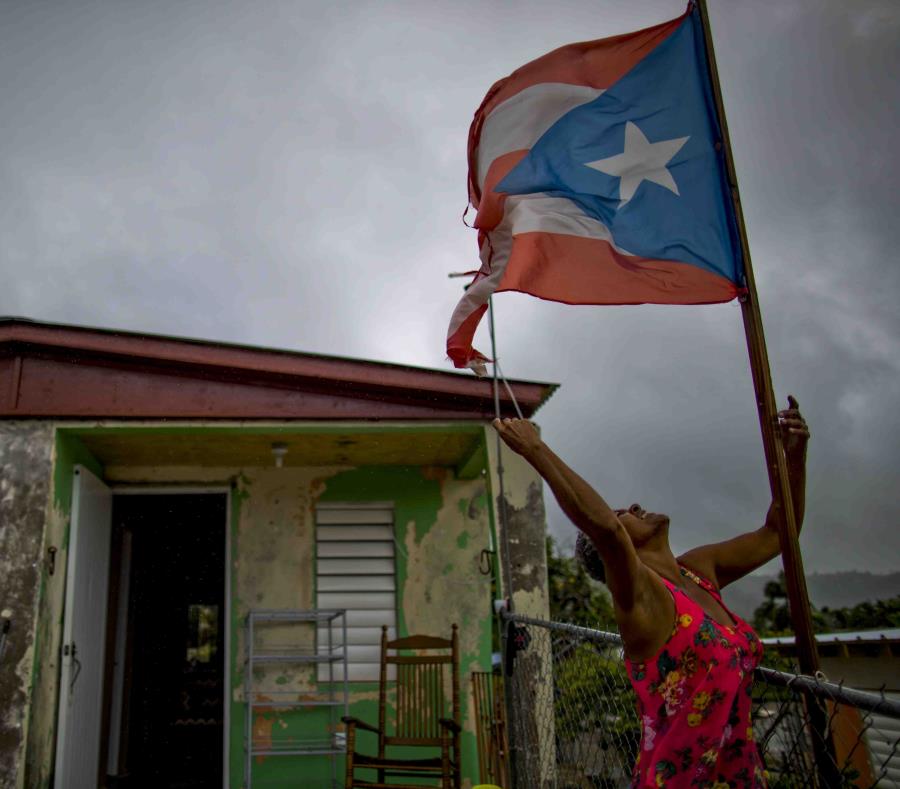 Una mujer frente a su residencia en Yabucoa durante el paso de Beryl por el sur de la isla (semisquare-x3)