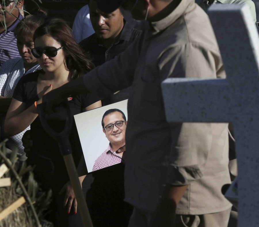 Fotografía de archivo del 31 de mayo de 2018, de un hombre portando un retrato del asesinado periodista Héctor González Antonio mientras su hija, a la izquierda, llora durante su funeral en la Ciudad de México. (AP) (semisquare-x3)
