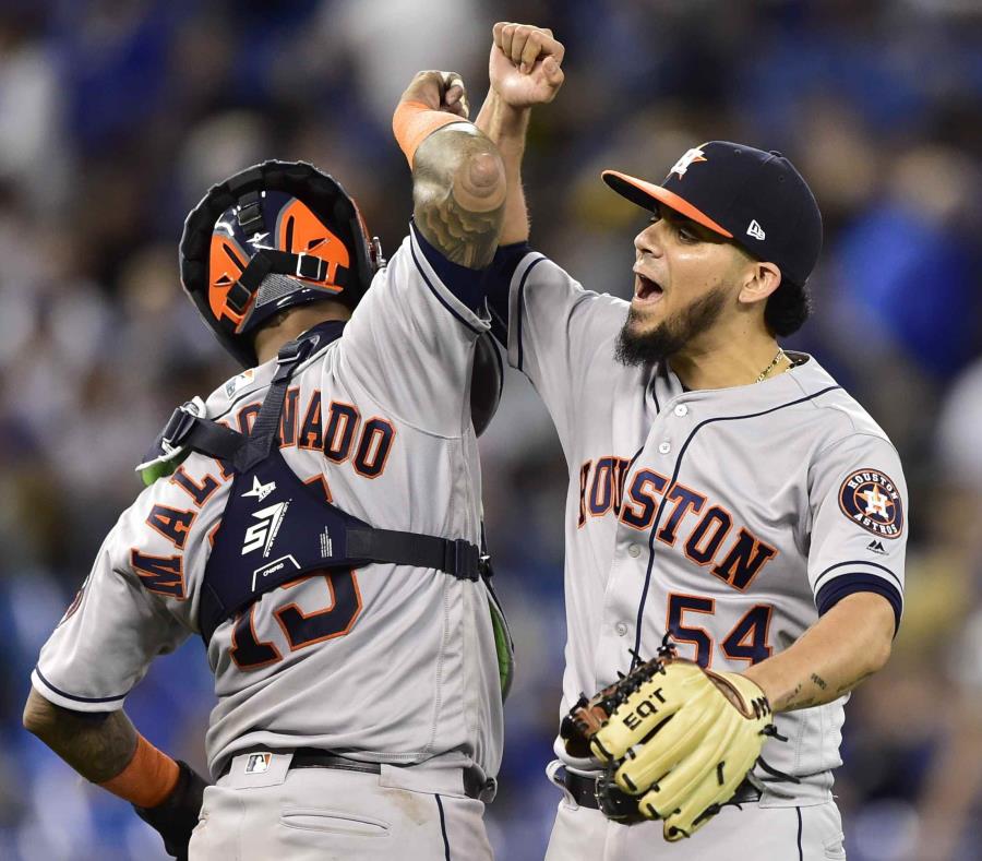 El receptor boricua Martín Maldonado y el relevista Roberto Osuna celebran la victoria. (AP) (semisquare-x3)