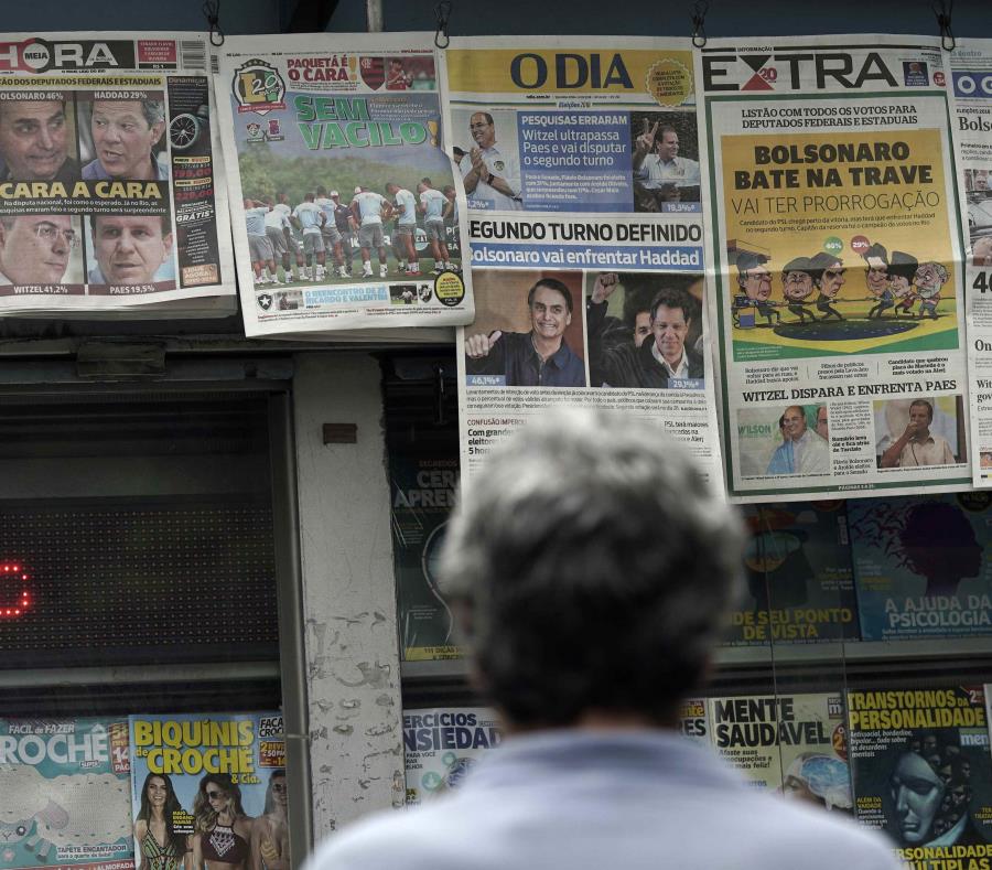 Un hombre lee los encabezados que anuncian los resultados de la elección presidencial de Brasil en Río de Janeiro. (AP / Leo Correa) (semisquare-x3)