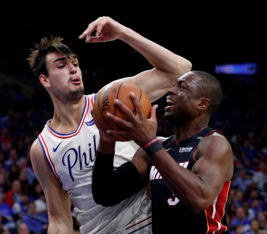 Dwyane Wade del Heat de Miami trata de disparar ante Dario Saric de los 76ers de Filadelfia