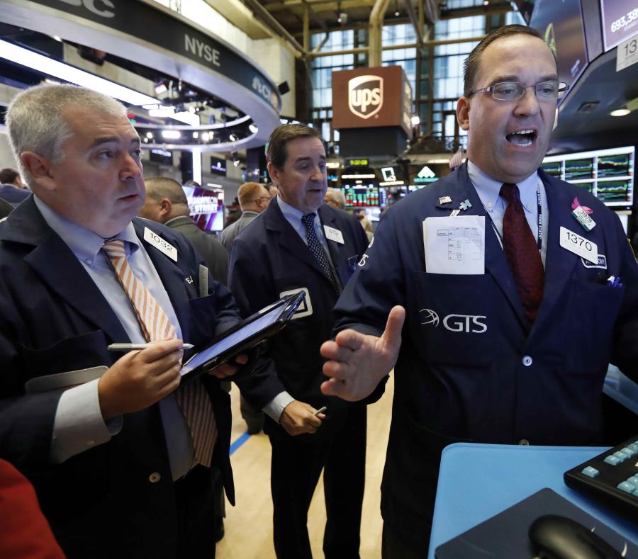 Trabajadores del New York Stock Exchange discuten una movida financiera. (AP) (semisquare-x3)