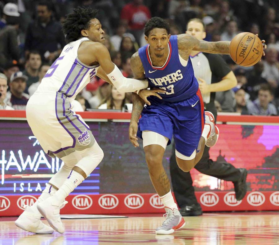 Lou Williams (23), de los Clippers de Los Ángeles, intenta superar la marca de De'Aaron Fox (5), de los Kings de Sacramento, en la primera mitad del encuentro en Los Ángeles. (semisquare-x3)