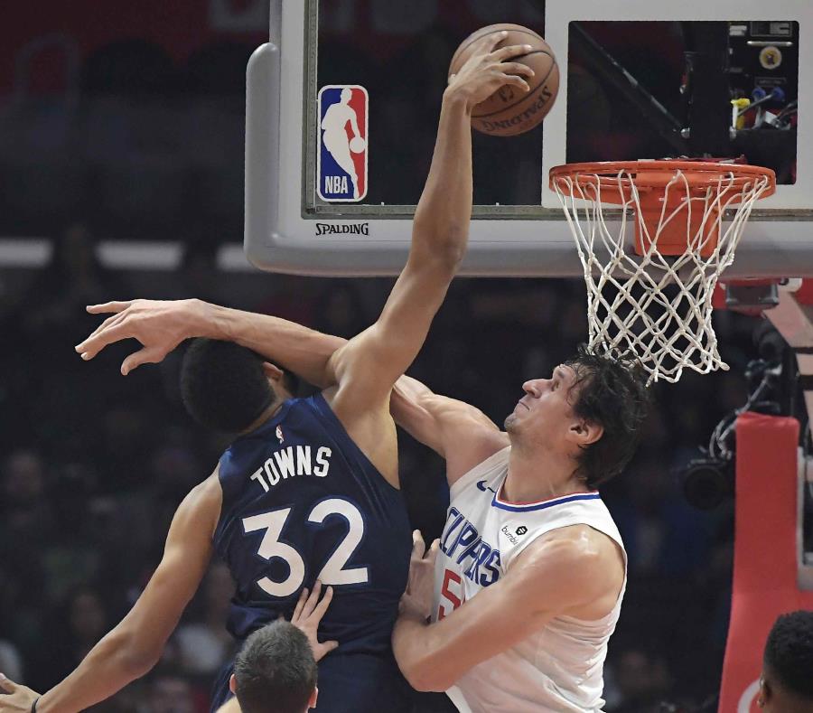 Karl-Anthony Towns (izquierda), de los Timberwolves de Minnesota lanza a canasta ante la defensa de su rival de los Clippers de Los Ángeles Montrezl Harrell, en la primera mitad del juego de la NBA que enfrentó a ambos equipos, el 5 de noviembre de 2018, (semisquare-x3)