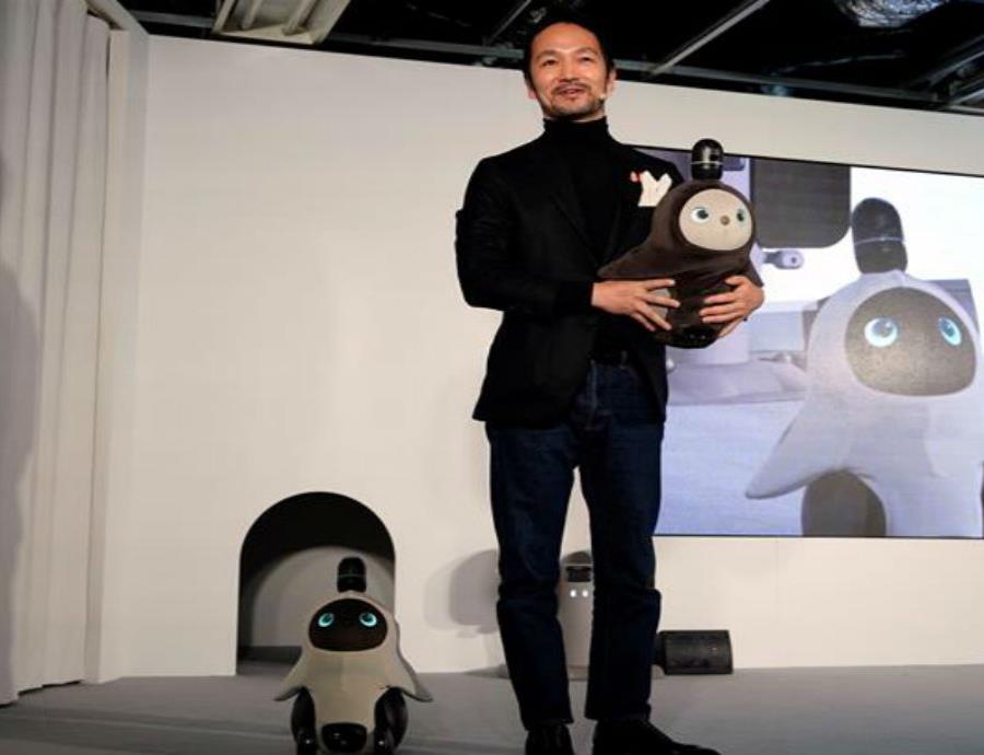 El ingeniero nipón Kamame Hayashi, responsable de la compañía Groove X, posa con sus nuevos robots domésticos
