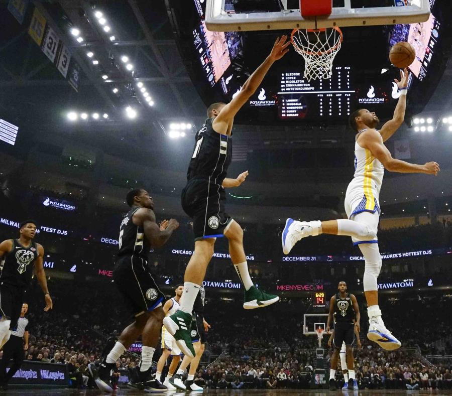 El jugador de los Warriors de Golden State Stephen Curry lanza a canasta en la primera mitad del juego de la NBA que enfrentó a su equipo con los Bucks de Milwaukee, el 7 de diciembre de 2018, en Milwaukee. (AP) (semisquare-x3)