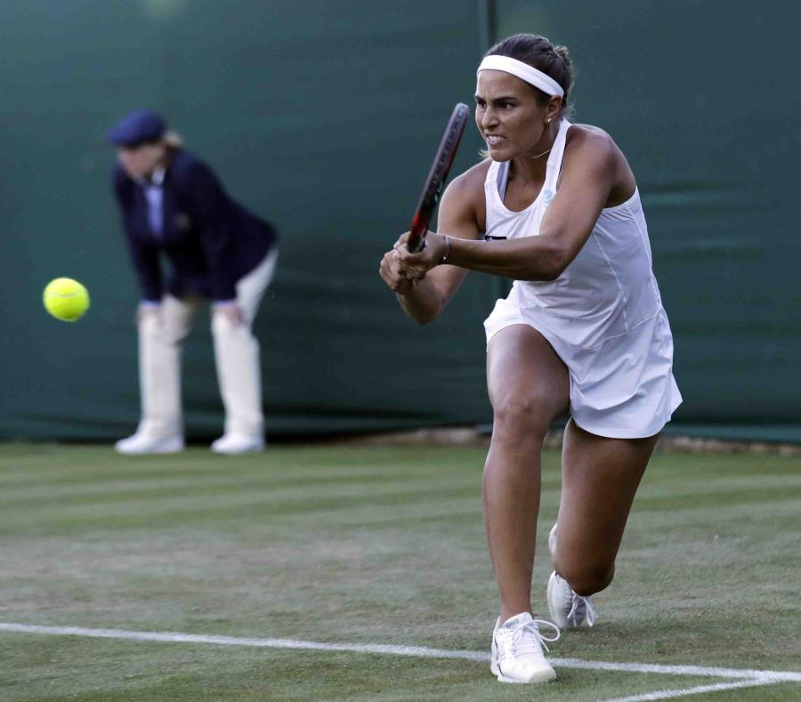Mónica Puig le devuelve la pelota a Julia Goerges durante el partido de hoy en Londres. (AP / Ben Curtis) (semisquare-x3)