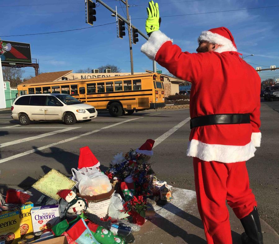 En esta fotografía del 18 de diciembre de 2018, Jimmy Izbinski, vestido con un traje de Santa, saluda a los automovilistas que pasan por una marihuana navideña en Toledo, Ohio. (AP) (semisquare-x3)