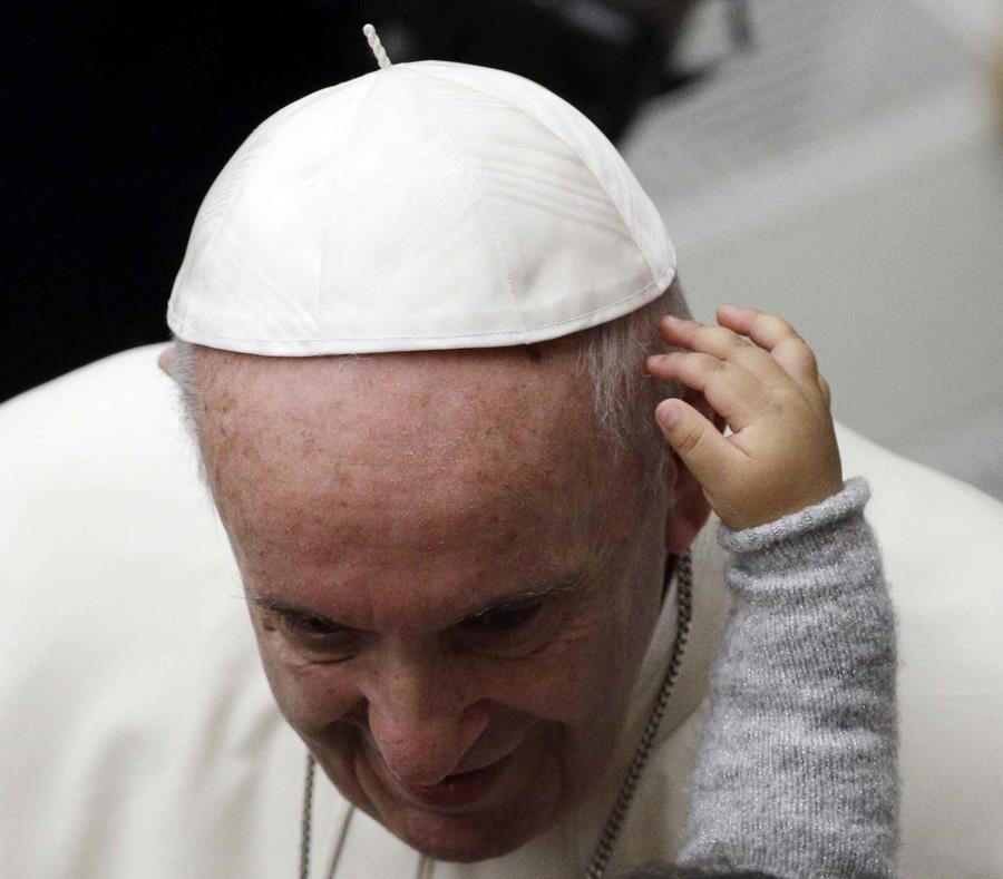 El papa Francisco es acariciado por un niño en el aula Pablo VI en el Vaticano, domingo 16 de diciembre de 2018. (AP) (semisquare-x3)