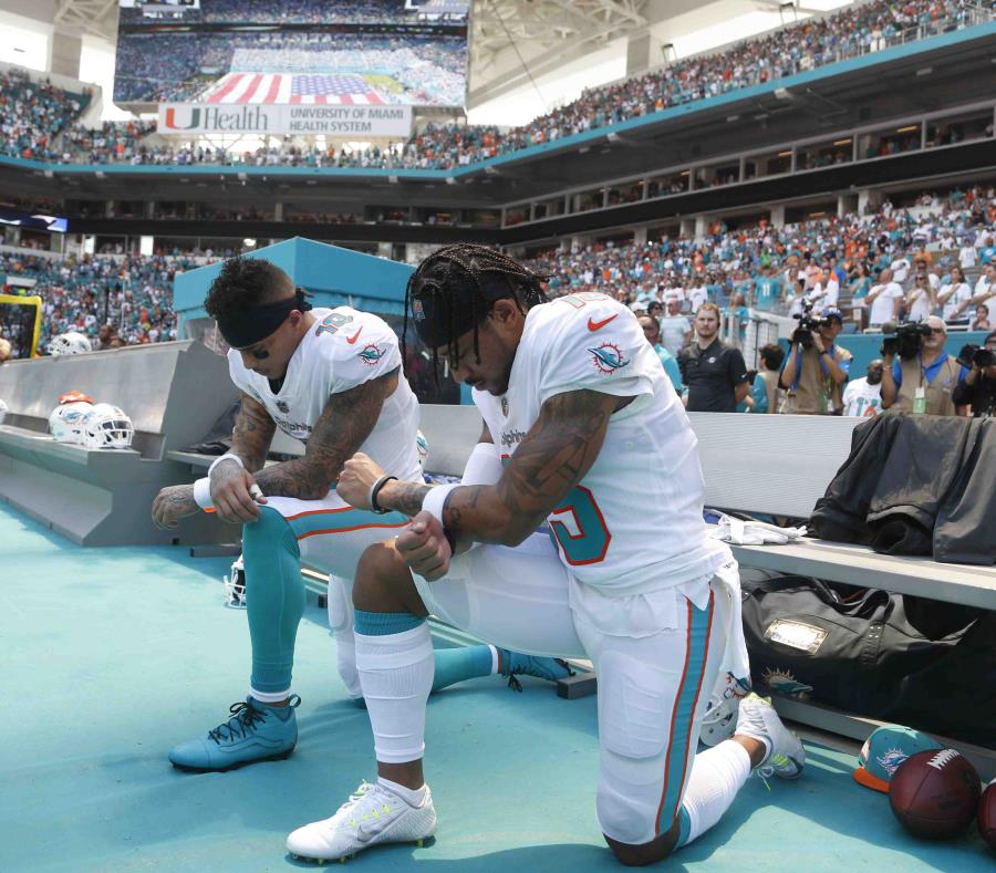 Kenny Stills y Albert Wilson arrodillados durante el himno nacional. (AP) (semisquare-x3)