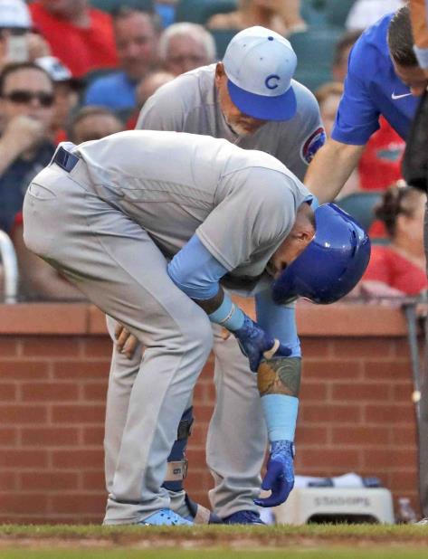 Javier Báez sostiene el codo de su brazo izquierdo luego de ser alcanzado por un pelotazo. (AP / Jeff Roberson) (vertical-x1)