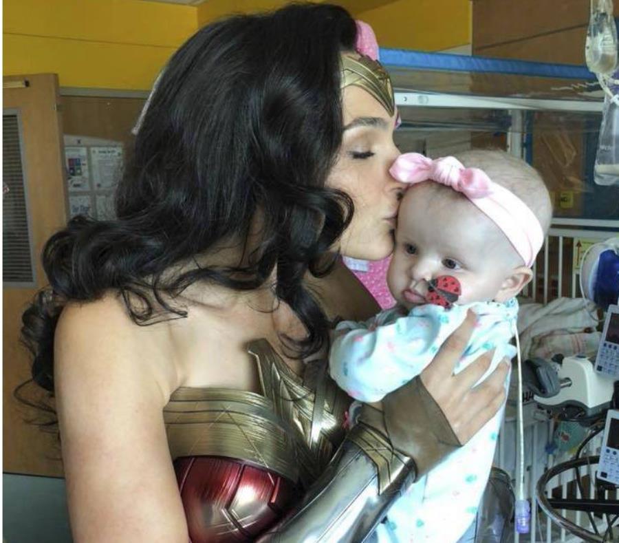 En esta imagen proporcionada por Kelly Swink Sahady la actriz Gal Gadot, vesitda como la Mujer Maravilla, besa a la hija de Sahady, Karalyne, durante una visita al Hospital de Niños Inova en Falls Church, Virginia. (AP) (semisquare-x3)
