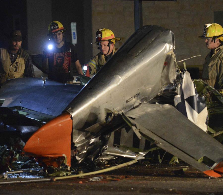 Los bomberos atienden la escena donde atienden el accidente de un avión vintage. (AP) (semisquare-x3)