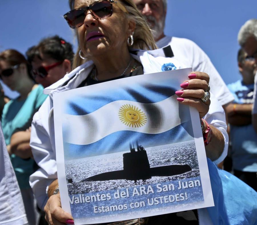 Una mujer sostiene un cartel con el mensaje