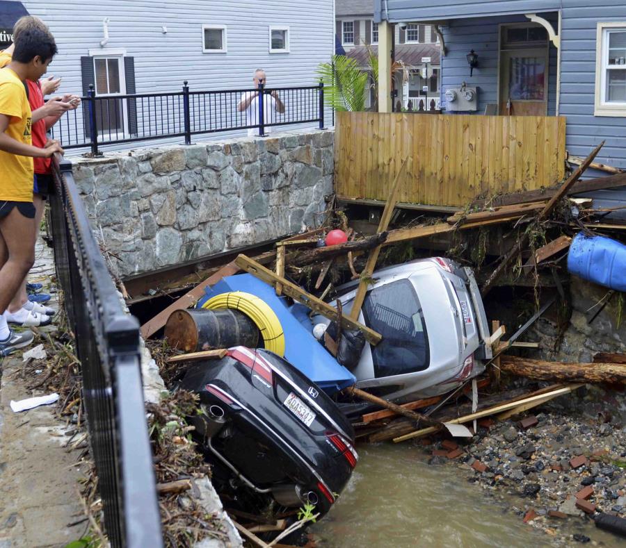 Residentes se reúnen en un puente para observar los daños causados por una inundación que arrasó con Ellicott City, en Maryland. (AP) (semisquare-x3)