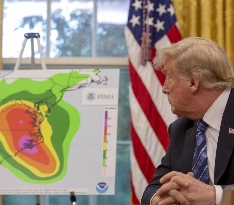 Trump observa un mapa del posible impacto del huracán Florence. (EFE / Tasos Katopodis) (semisquare-x3)