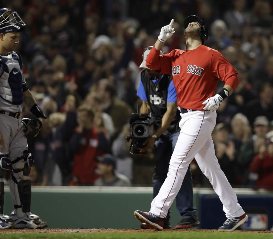 El jugador de los Medias Rojas de Boston, J.D. Martínez, apunta al cielo luego de pegar un jonrón de tres carreras, mientras pasa cerca del receptor de los Yanquis de Nueva York, el dominicano Gary Sánchez (semisquare-x3)