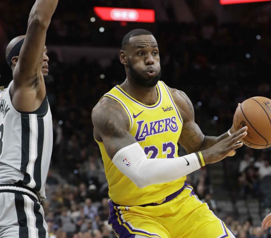 LeBron James busca evitar la defensa de Dante Cunningham. (AP) (semisquare-x3)