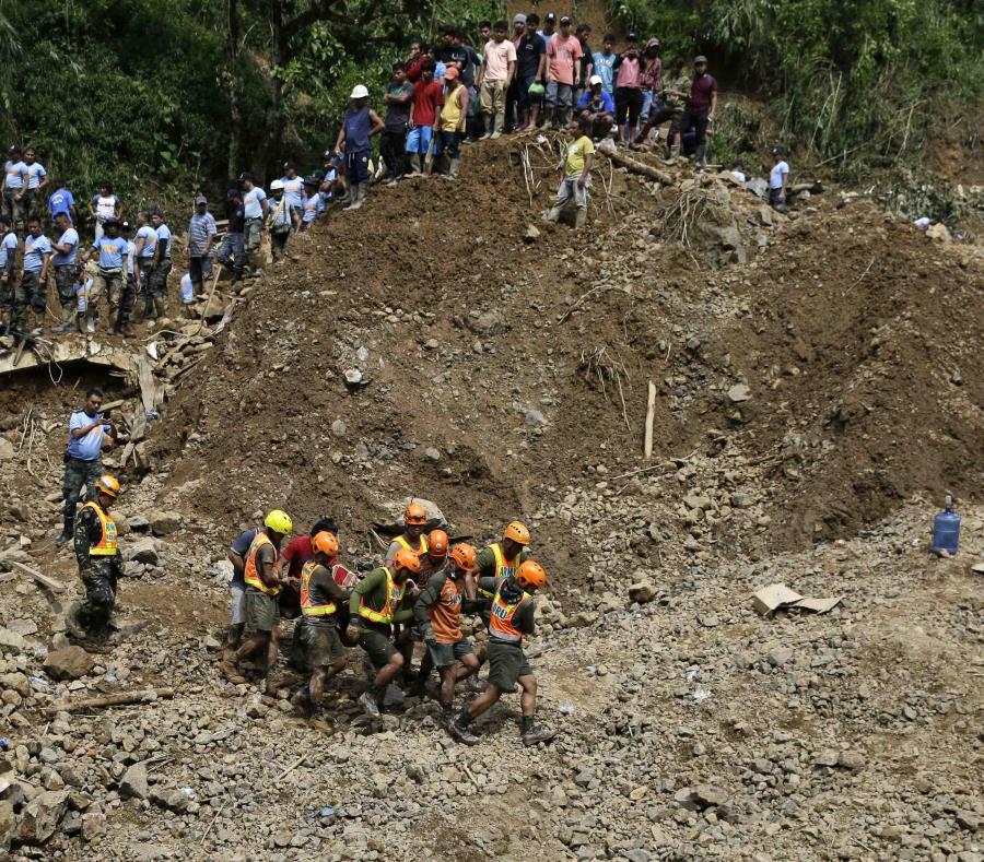 Socorristas recuperan el cadáver de una persona donde varias de ellas quedaron sepultadas debido a un alud de tierra y piedras después del tifón Manghkut que azotó Itogón, provincia de Benguet, en el norte de Filipinas. (AP) (semisquare-x3)
