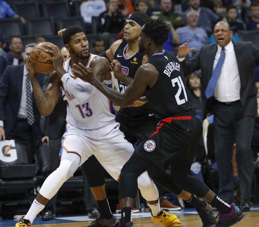 El alero Paul George (13) del Thunder de Oklahoma City busca a algún compañero para enviarle un pase mientras el base Patrick Beverley (21) y el ala-pívot Tobias Harris (34) de los Clippers de Los Ángeles intentan detenerlo, en Oklahoma City, el sábado 15 (semisquare-x3)