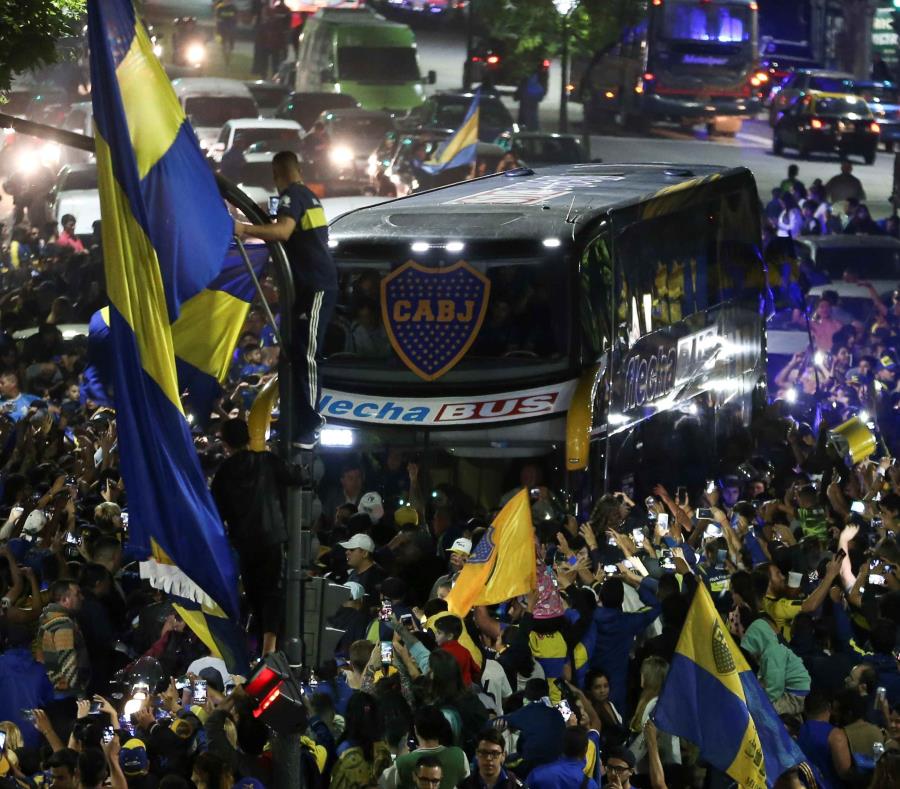 El bus que transporta a los jugadores del Boca Juniors es recibido por aficionados que se reúnen para despedir al equipo en el denominado