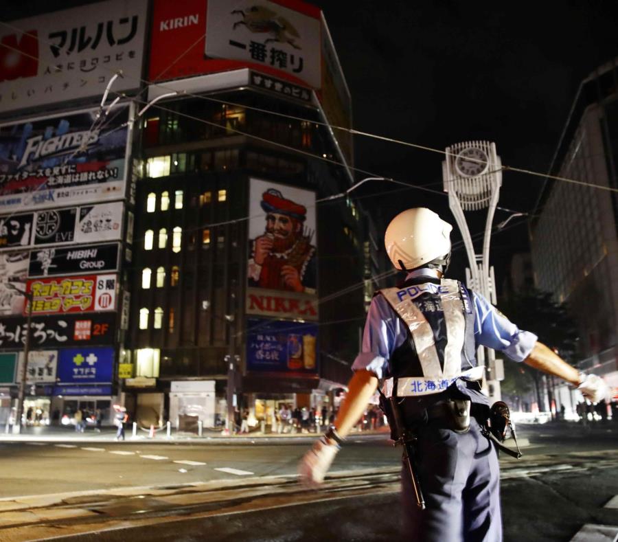 Un agente de policía controla el tránsito durante un apagón a causa de un fuerte sismo. (AP) (semisquare-x3)