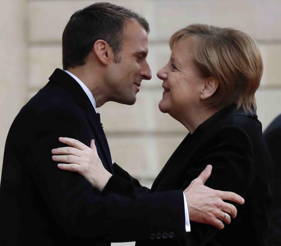 El mandatario francés Emmanuel Macron y la canciller alemana Angela Merkel se saludan en los jardines el Palacio del Elíseo en París, el 11 de noviembre de 2018. (AP) (semisquare-x3)