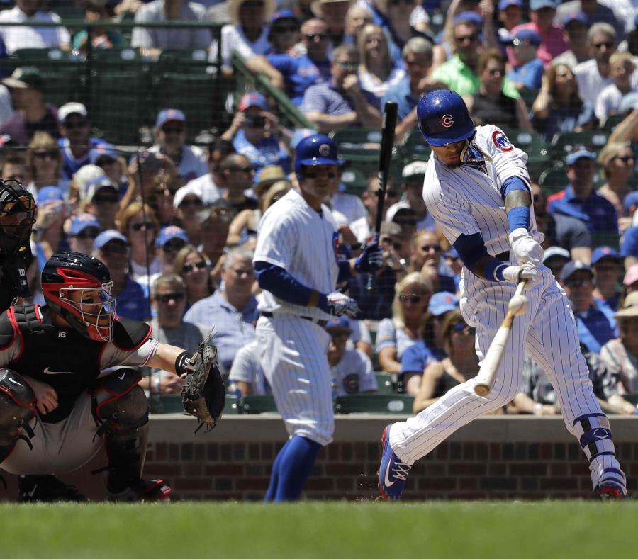 Chicago Cubs' Javier Baez, right, hits a double during the first inning of a baseball game against the Cincinnati Reds, Sunday, July 8, 2018, in Chicago. (AP Photo/Nam Y. Huh)Javier Báez, de los Cachorros de Chicago, pega un doblete durante la primera ent (semisquare-x3)