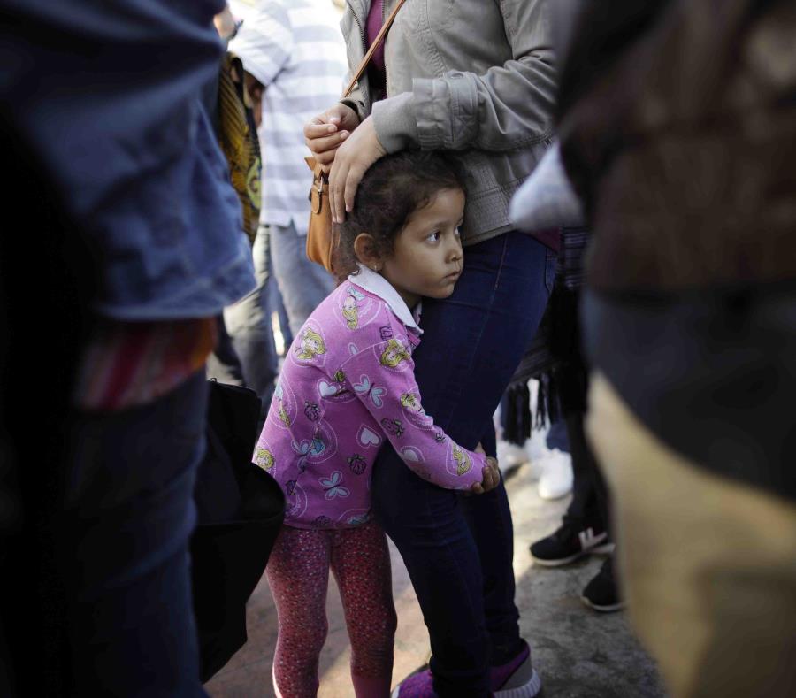 Nicole Hernández, de Guerrero en México, se aferra a las piernas de su mamá mientras aguardan para solicitar asilo político en la frontera en los Estados Unidos mediante el cruce fronterizo en Tijuana. (AP / Gregory Bull) (semisquare-x3)
