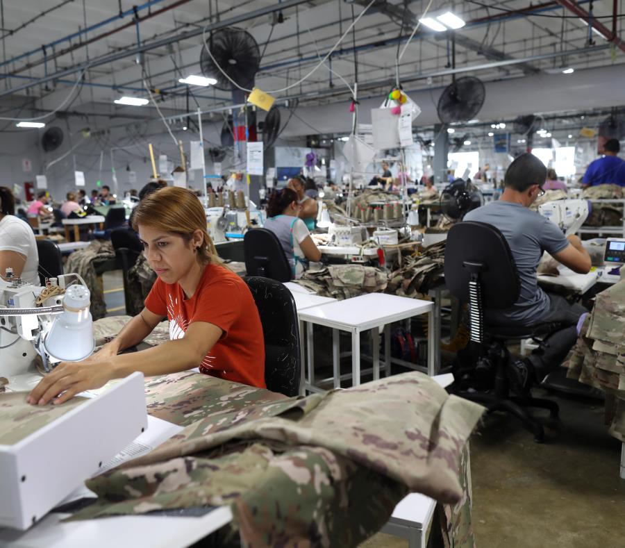 Anelis Jiménez (camisa roja) y otros empleados en la fábrica de SNC Technical Services, en Camuy. (semisquare-x3)