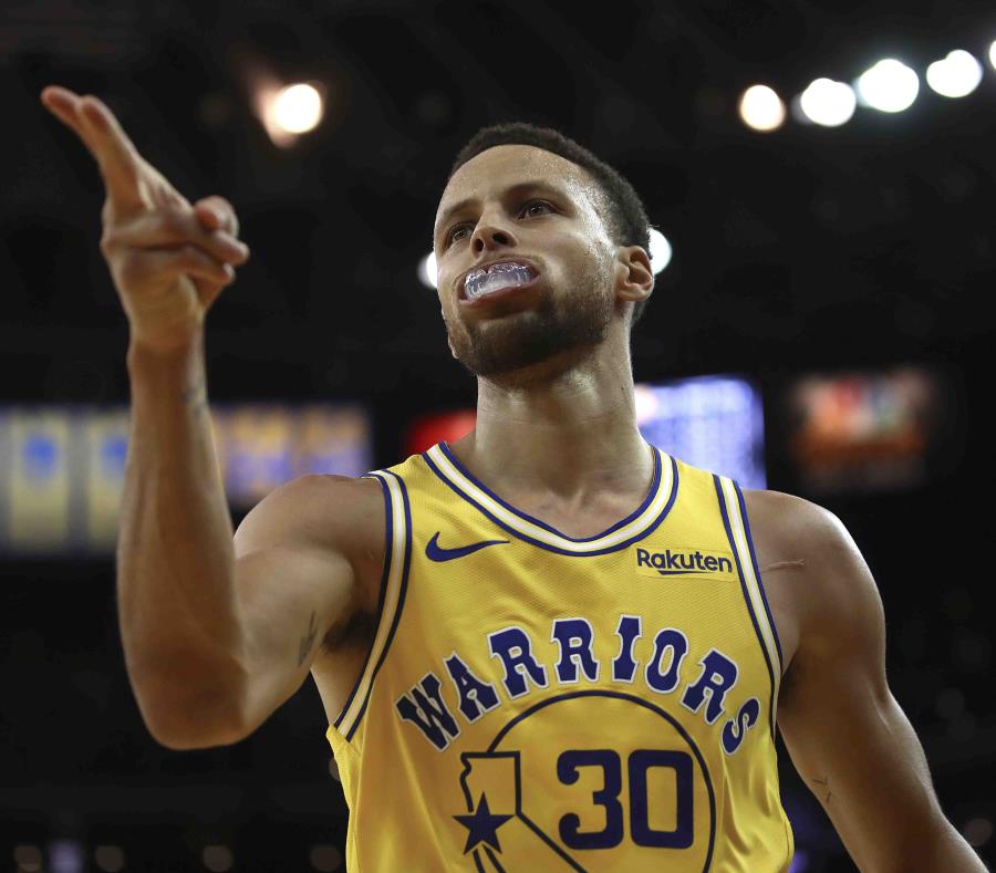 Stephen Curry apunta con dos de sus dedos luego de marcar un canasto en el desafío contra los Wizards de Washington. (AP / Ben Margot) (semisquare-x3)