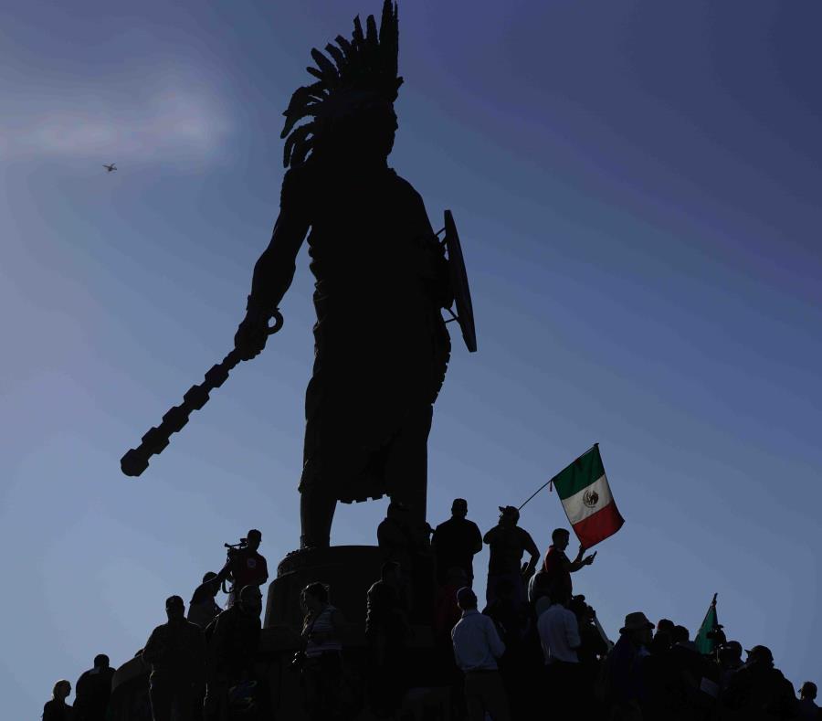 Los protestantes se congregan en torno a un monumento en un barrio pudiente de la ciudad para protestar la presencia de los miles de migrantes centroamericanos. (AP) (semisquare-x3)