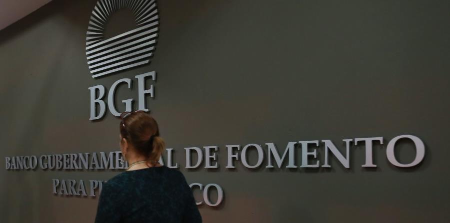 Una mujer camina frente al logo del Banco Gubernamental de Fomento. (GFR Media) (horizontal-x3)