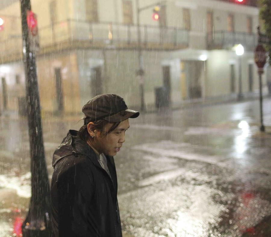 Charles Phanthapannha aguarda bajo la lluvia afuera de un bar de Mobile, Alabama, mientras la tormenta tropical Gordon se acerca. (AP / Dan Anderson) (semisquare-x3)