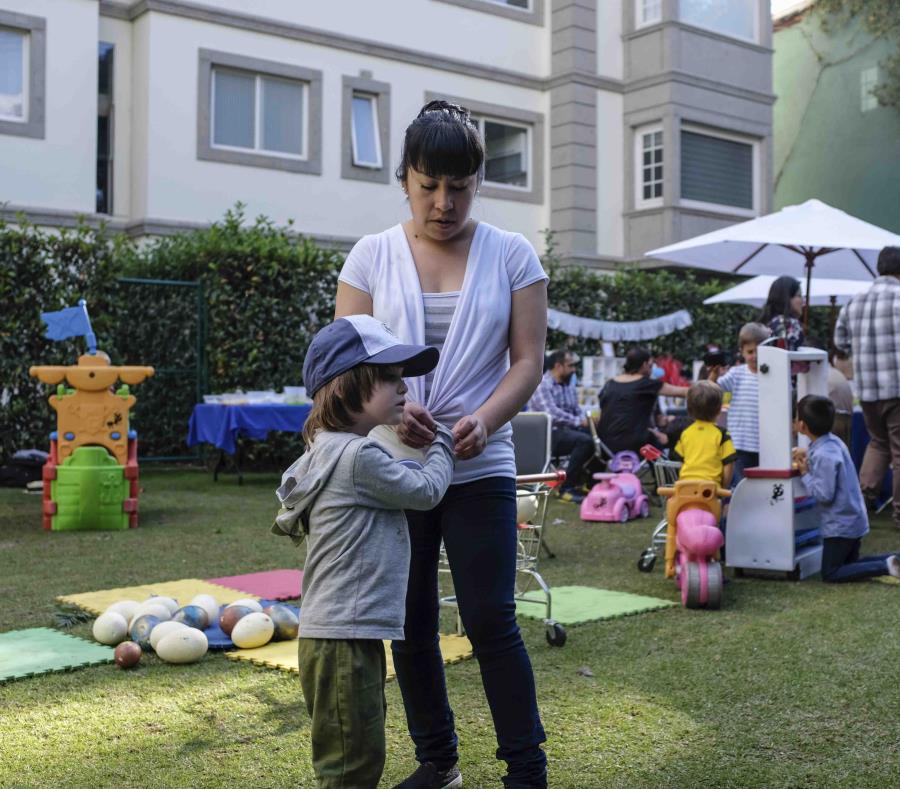 En esta fotografía del 8 de diciembre de 2018, Viviana López, nana de Teo, de 3 años, le enrolla la manga durante su fiesta de cumpleaños en Naucalpan, México (semisquare-x3)