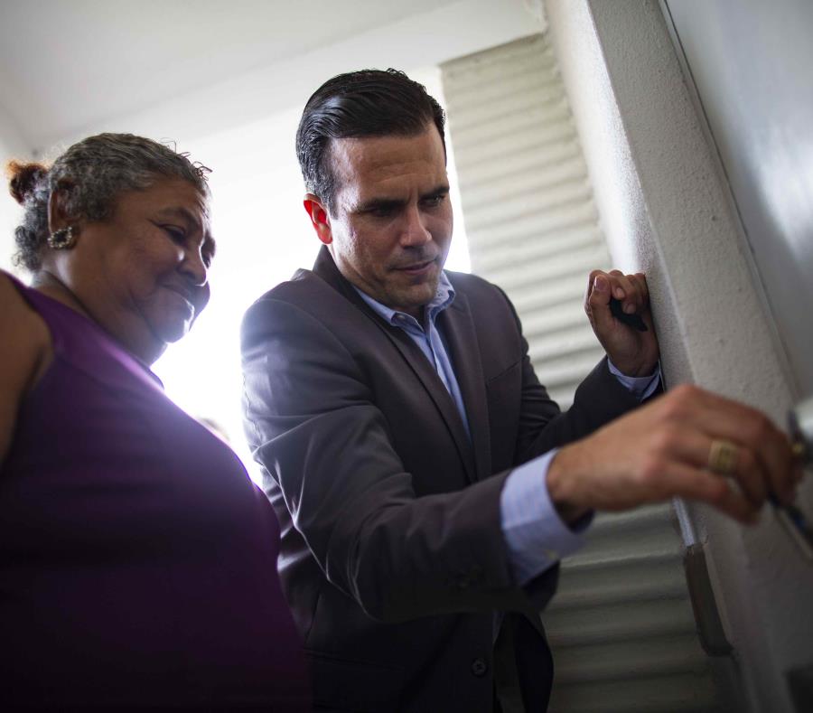 El gobernador Ricardo Rosselló ayuda a una señora a abrir la puerta de su nuevo hogar. (semisquare-x3)